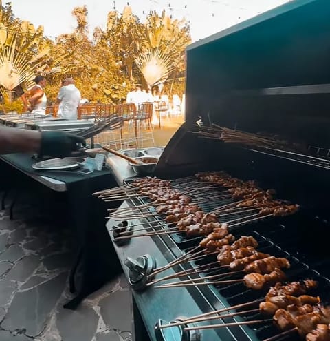 Satay skewers and steak grilling at a Bali villa BBQ